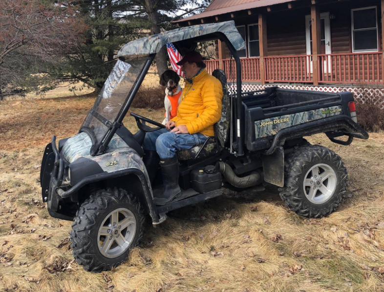 Man and dog in a John Deer UTV